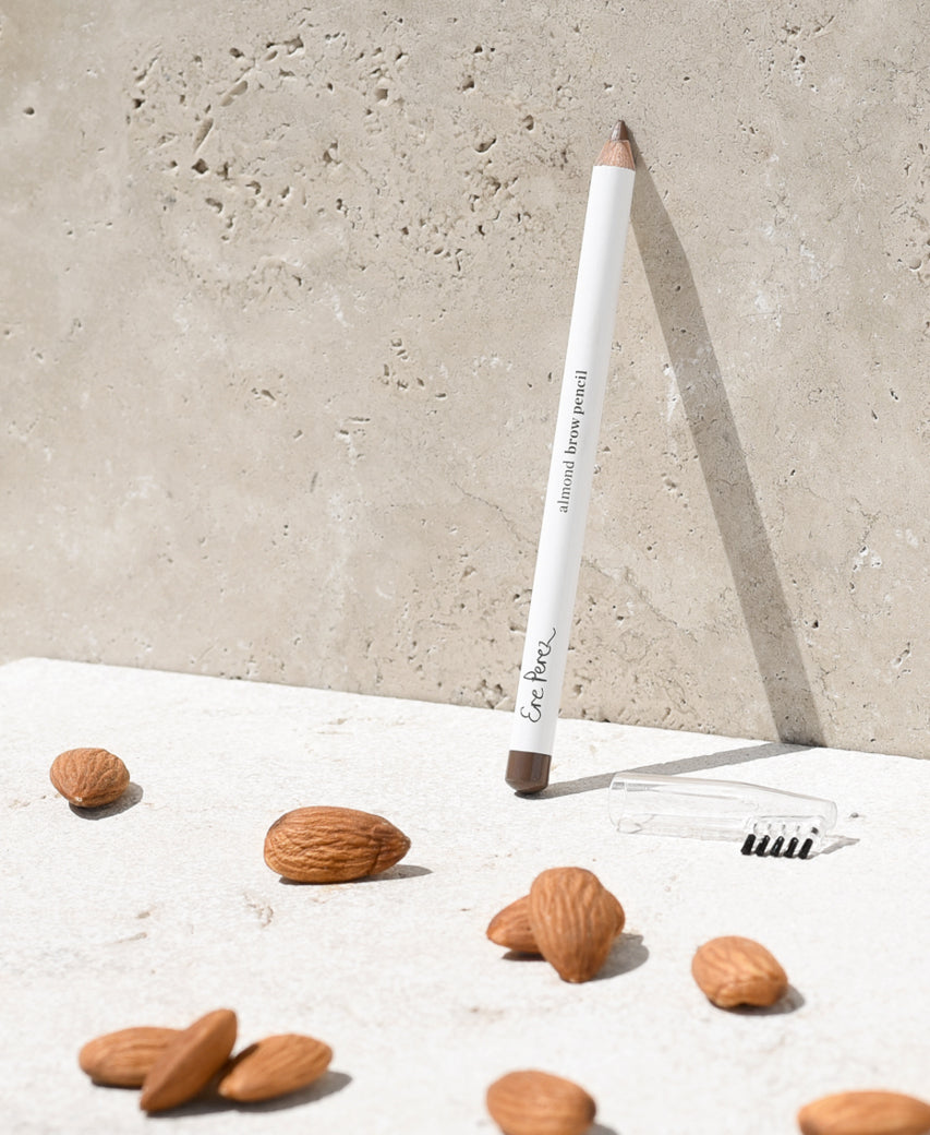 eco-friendly almond brow pencil in its sustainable packaging and with its built in applicator, next to its star ingredient: almonds
