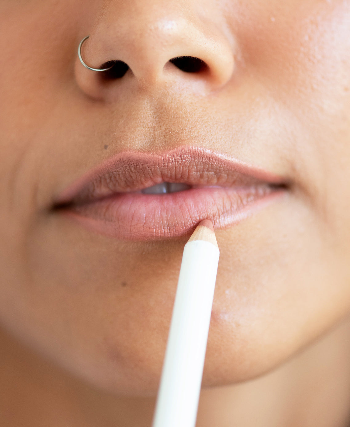 natural açai lip liner by Ere Perez in its pencil and applied to overline and hydrate lips