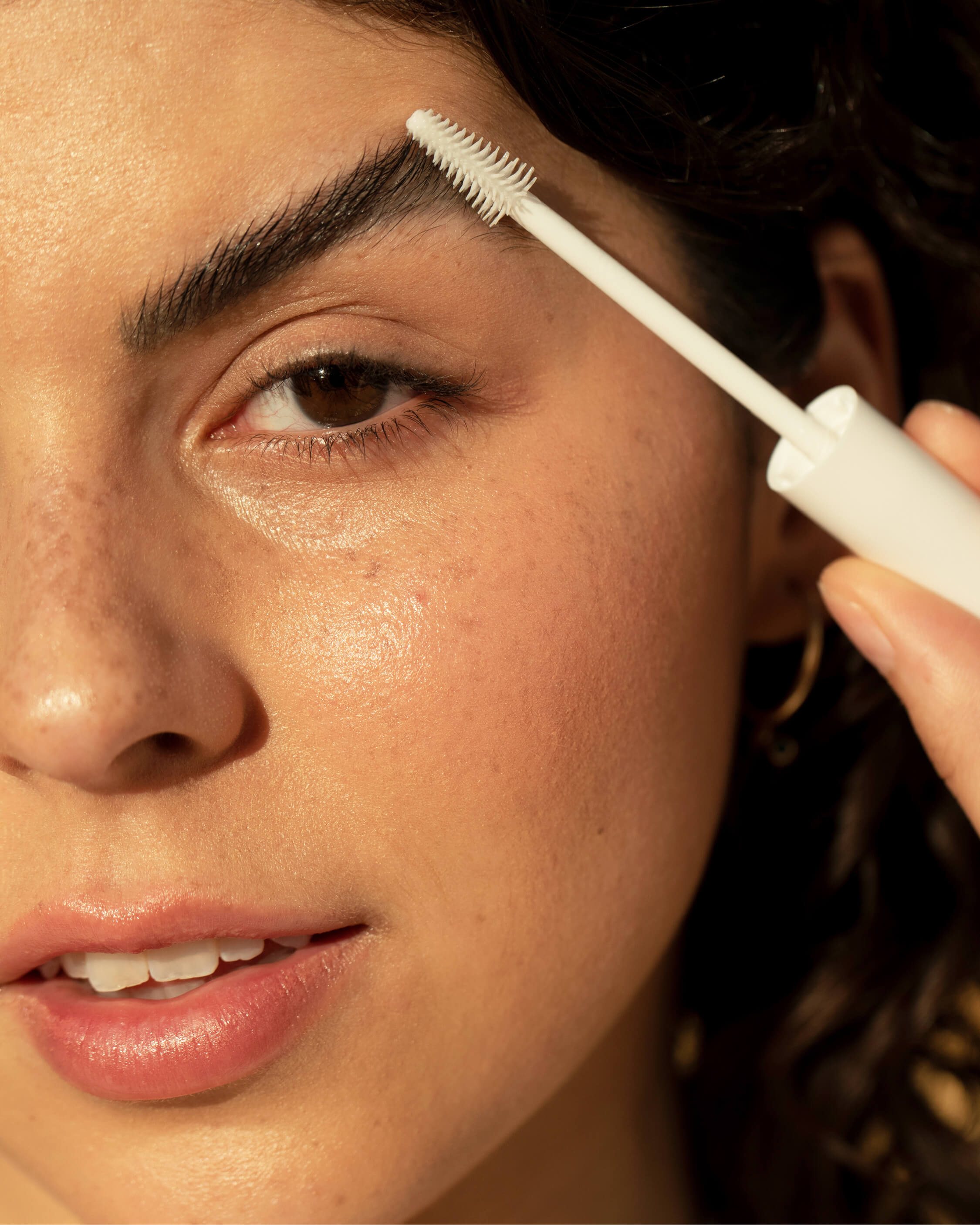 Natural aloe gel lash & brow mascara by Ere Perez in bottle and applied on brows and lashes for discrete lengthening effect