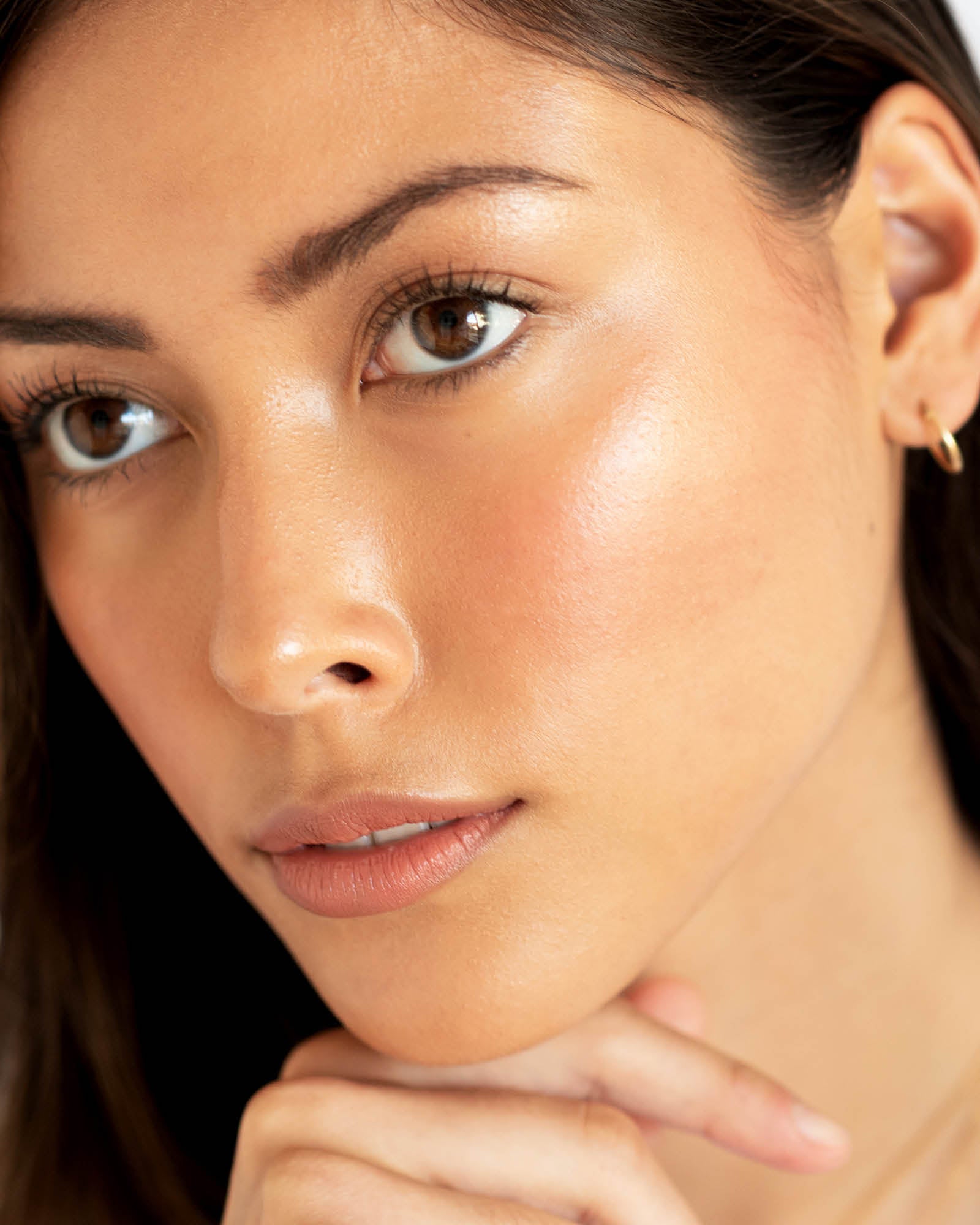 Close-up of a person who has applied Arnica All Cover Pot to their face. Arnica All Cover Pot in the shade brew