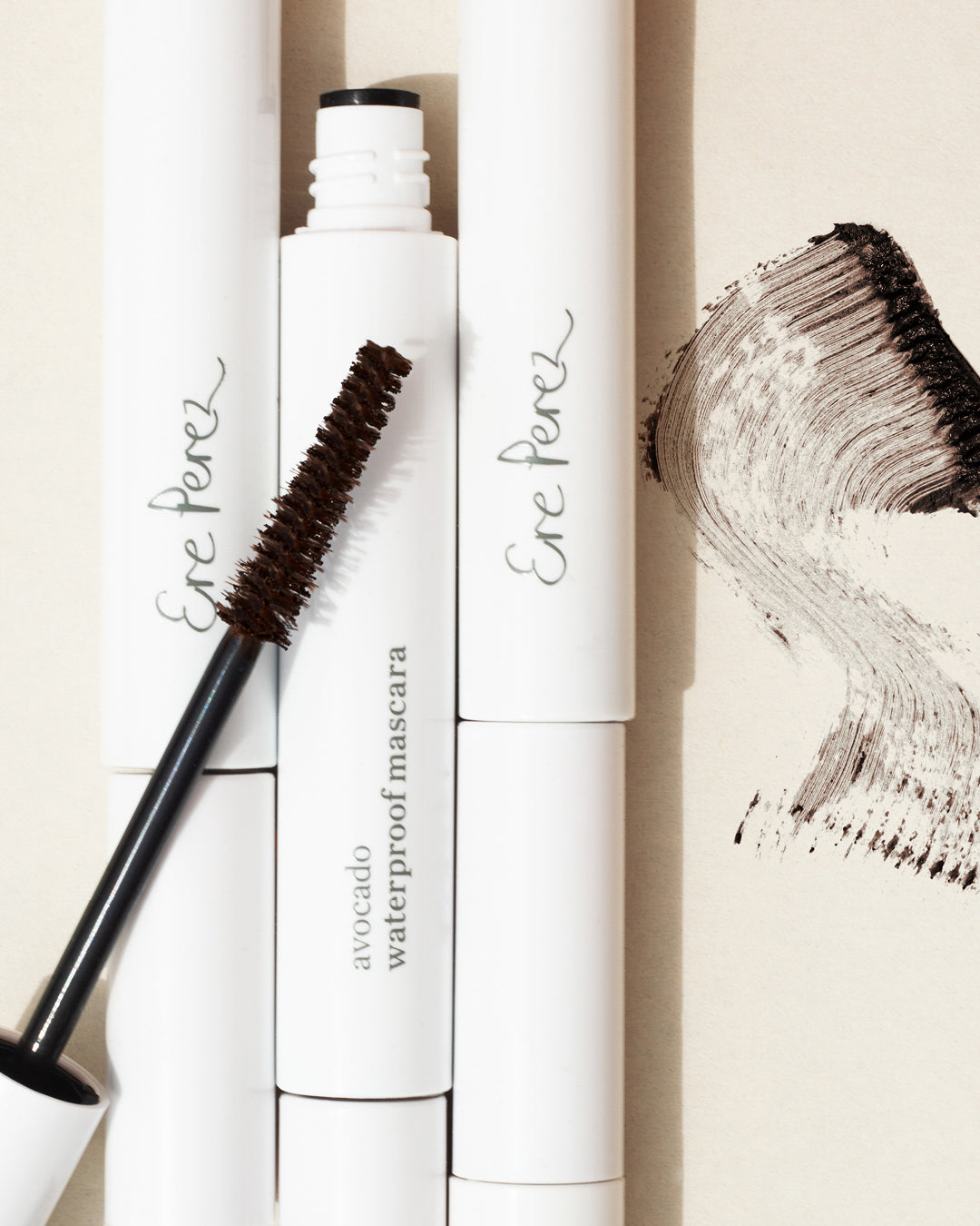 multiple tubes and a swatch of vegan and natural avocado waterproof mascara by Ere Perez