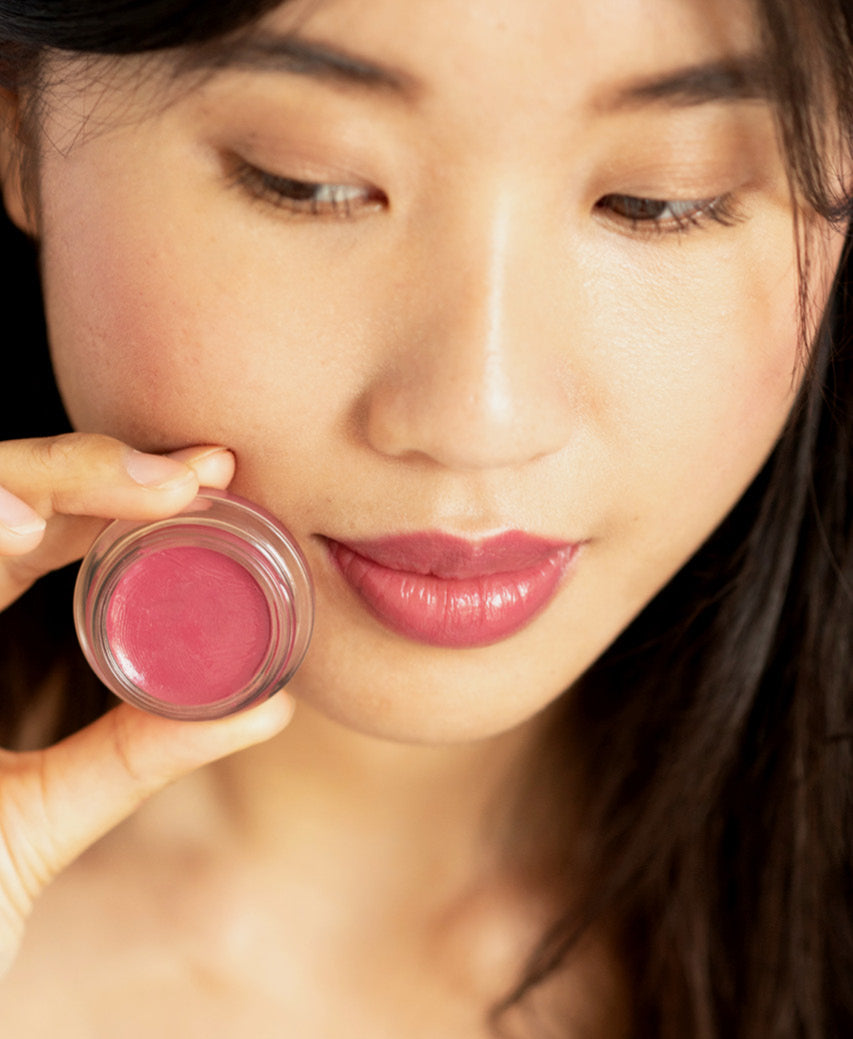 natural carrot colour pot by Ere Perez applied on the lips and in its pot for hydrated rosy effect