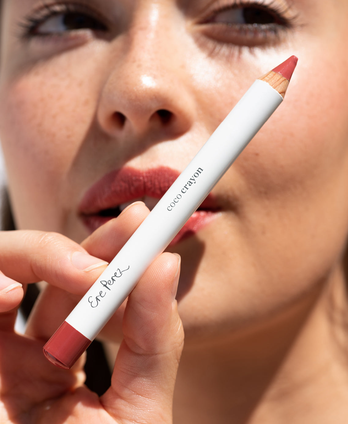 delicate moisturising coco crayon by Ere Perez applied on skin and in its plastic free crayon for a natural long-lasting colour