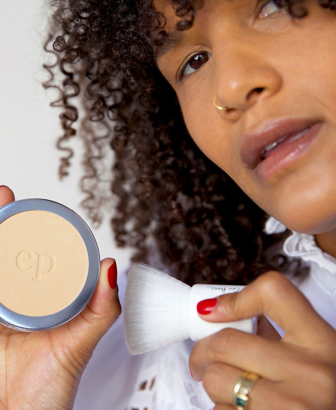 all-natural & gentle corn setting powder in wheel and applied on skin for a balanced look