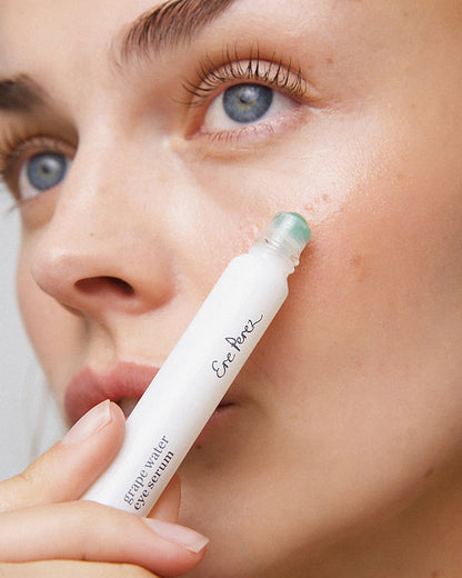 eco-friendly grape water eye serum in its sustainable eye roller and applied on the skin for moisturised skin