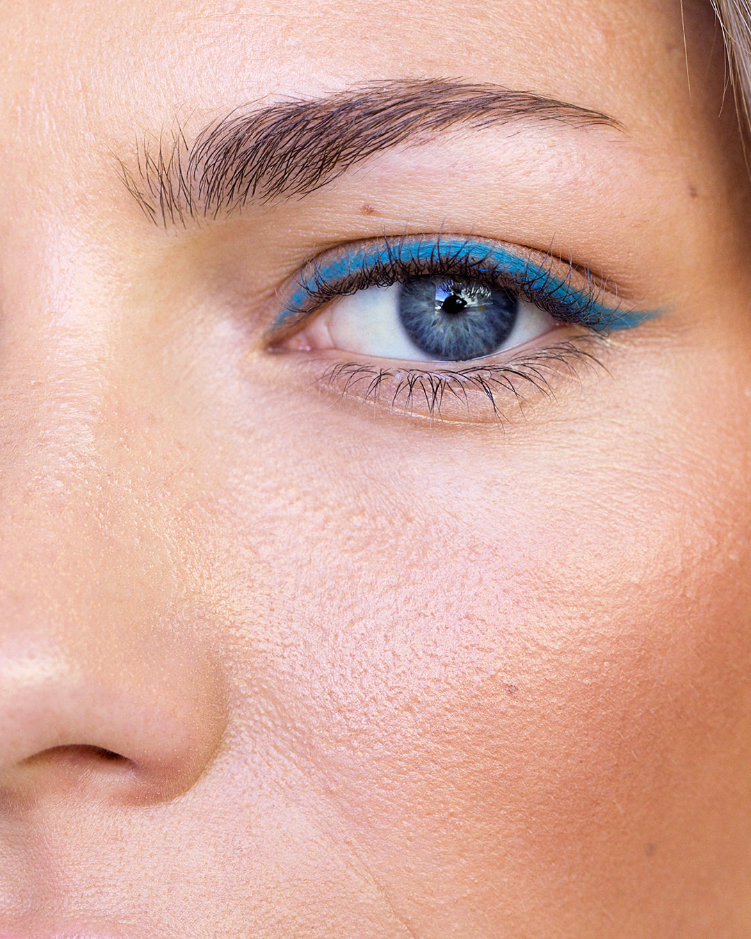 blue all-natural jojoba eye pencil applied on the eye for a defined eye with a pop of colour
