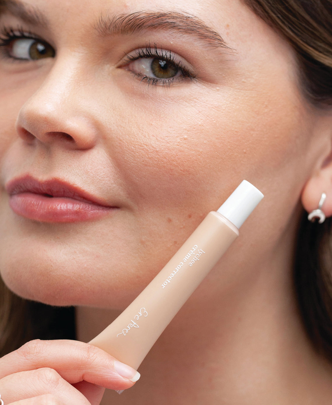 all-natural & hydrating lychee creme corrector in bottle and applied on skin for even complexion