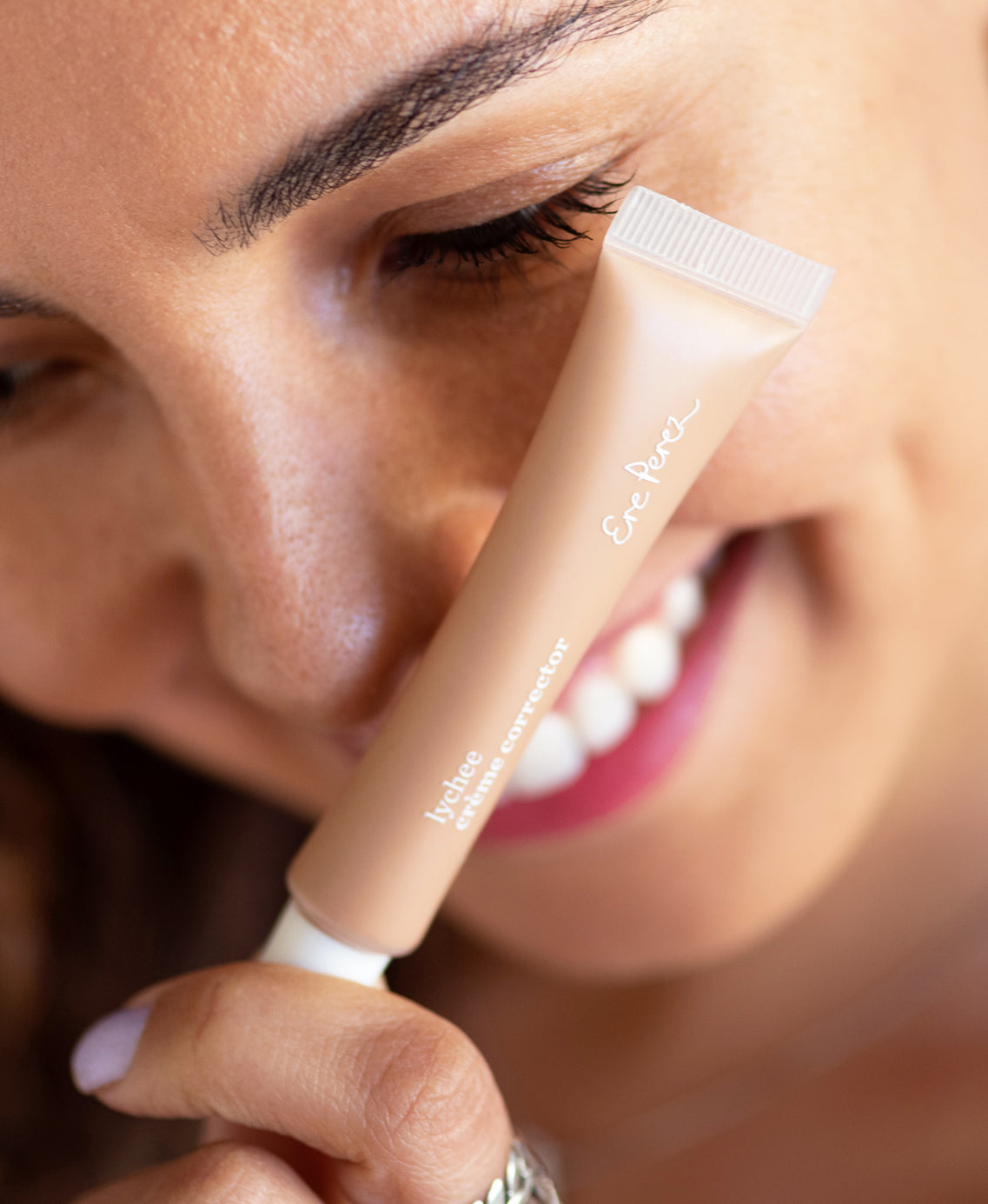 Organic & hydrating lychee creme corrector in bottle and applied on skin for even complexion