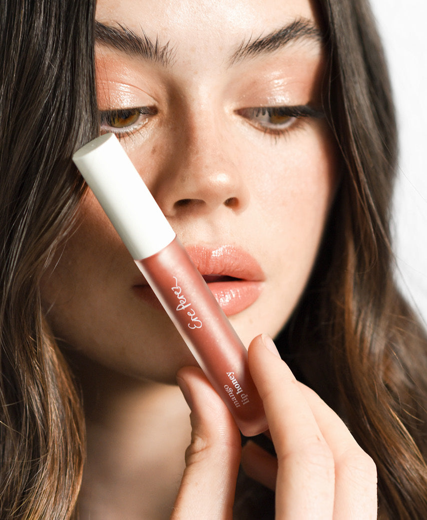 all-natural mango lip honey Ere Perez in its tube and applied on the lips for a plump shiny look