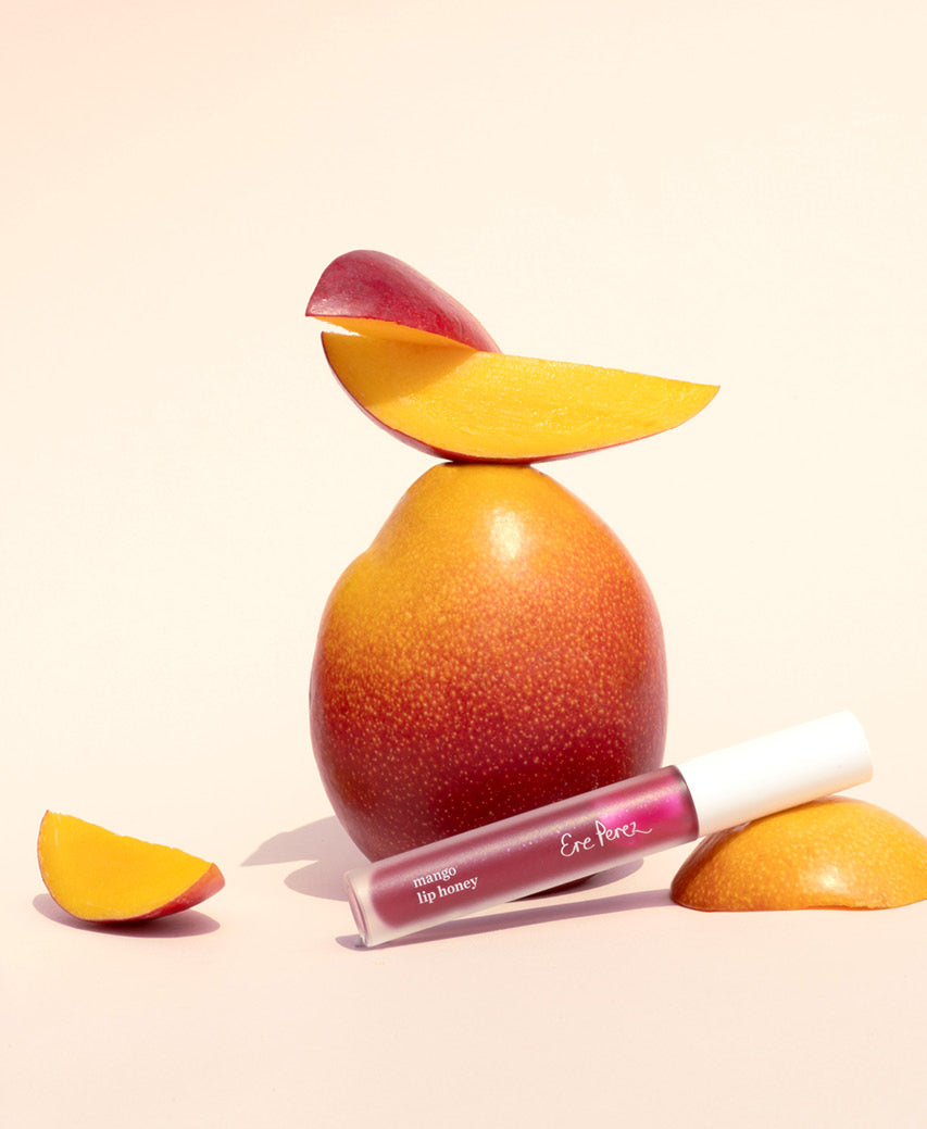 vegan mango lip honey Ere Perez next to its star ingredient: mango