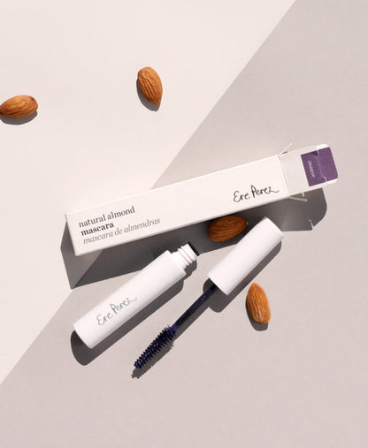Mauve natural almond mascara by Ere Perez in its tube packaging surrounded by its star ingredient: almonds