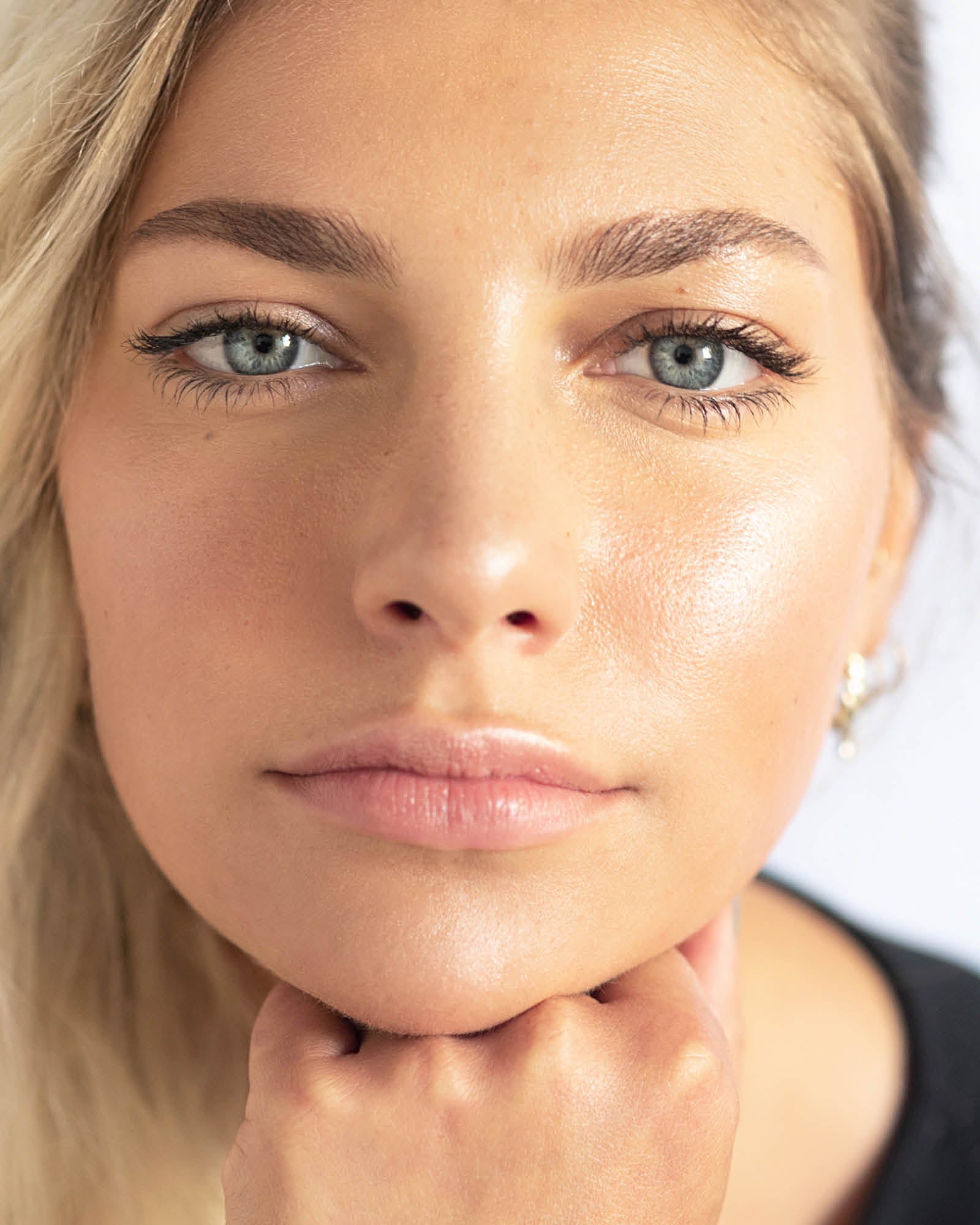 Close-up of a woman with clear skin and blue eyes,