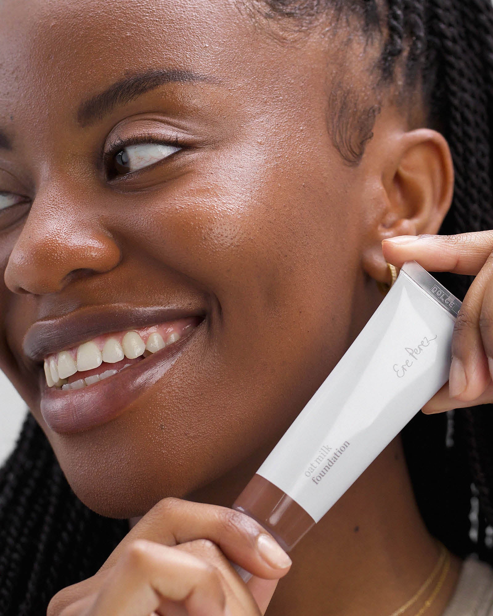 Woman holding a makeup product with a focus on the product&