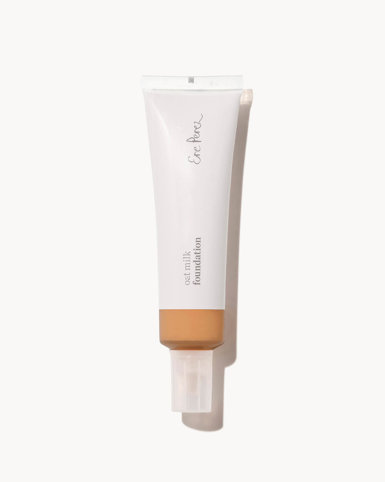 Tube of foundation in shade syrup with a white cap on a white background,