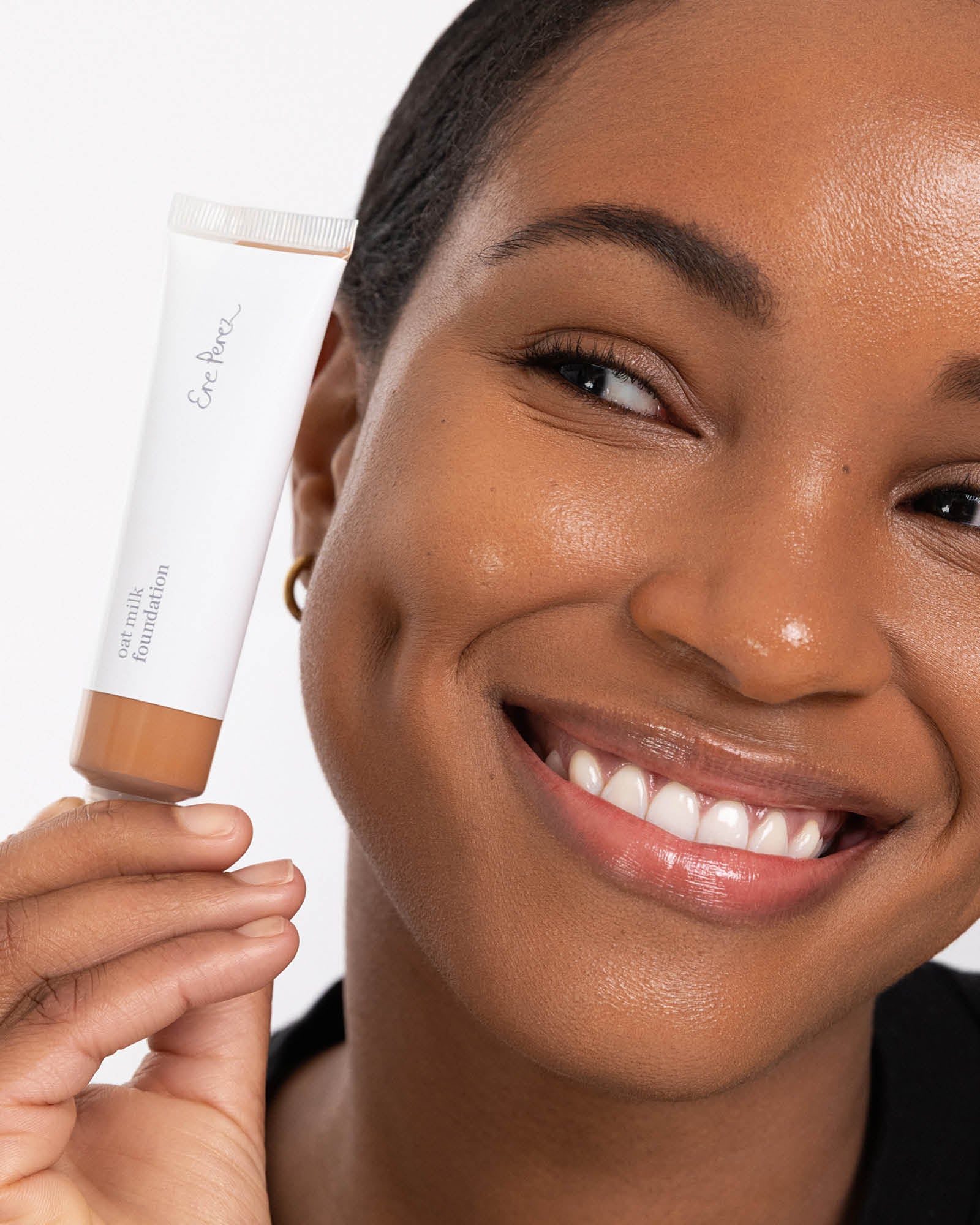 Woman holding a cosmetic product with a white background,