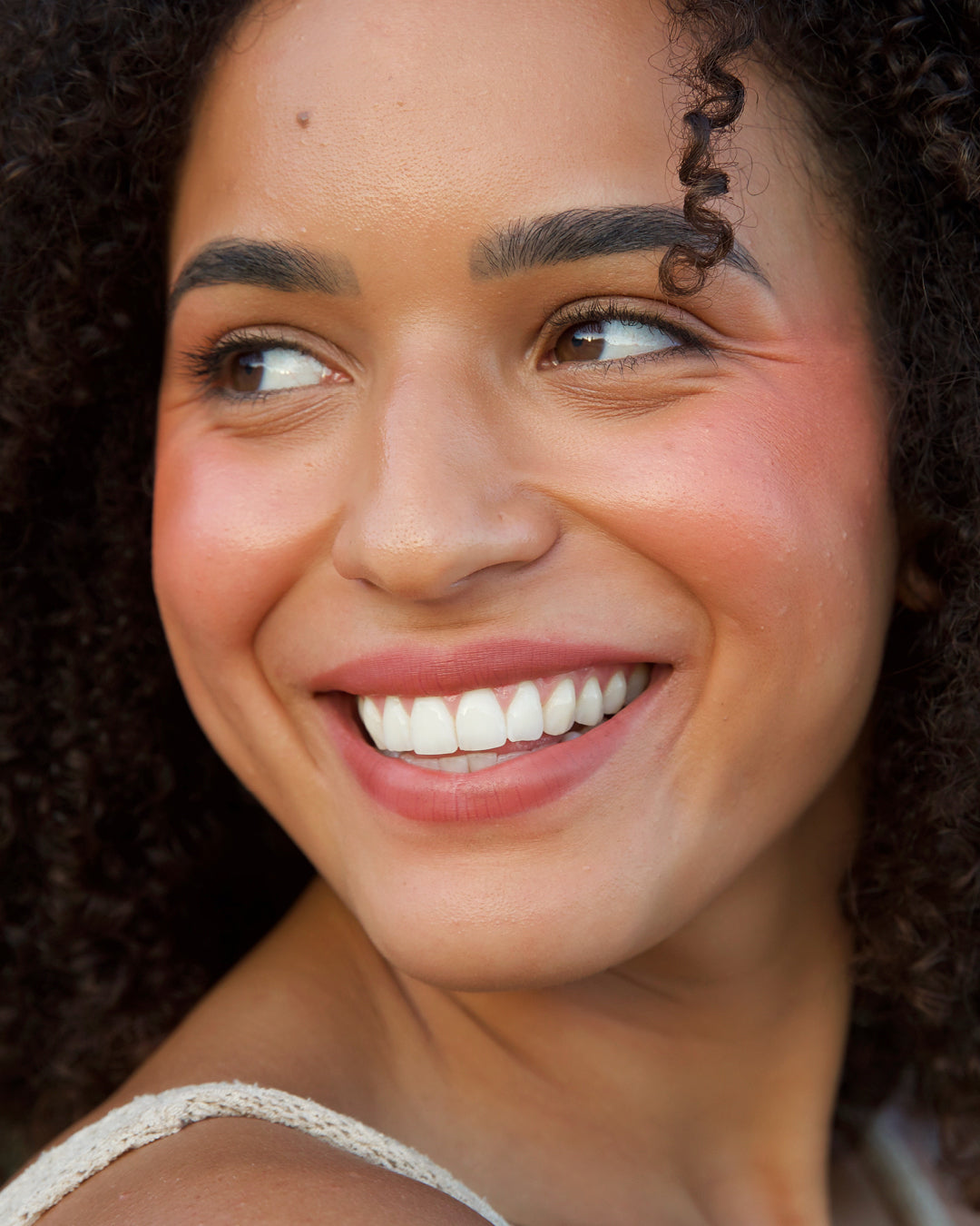 natural & delicate rice powder blush in its wheel and applied on skin for warm youthful cheeks