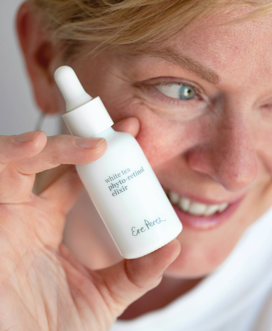 carbon-neutral skincare with white tea phyto-retinol elixir Ere Perez in its sustainable bottle and applied on the skin|