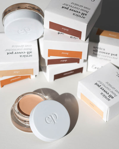 Set of many Arnica All Cover Pots makeup products on a white background with packaging 