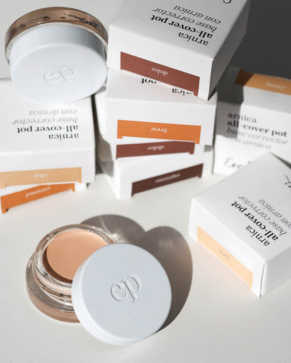 Set of many Arnica All Cover Pots makeup products on a white background with packaging 