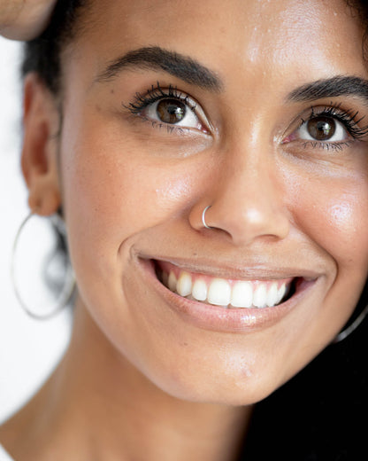 Close-up of a person who has applied Arnica All Cover Pot to their face. Arnica All Cover Pot in the shade brew 