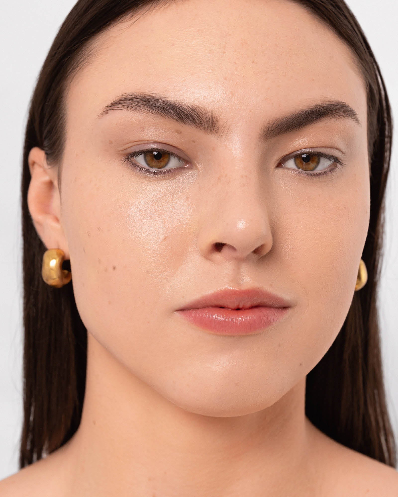 Close-up of a person applied Arnica All Cover Pot to their face. Arnica All Cover Pot in the shade Honey 
