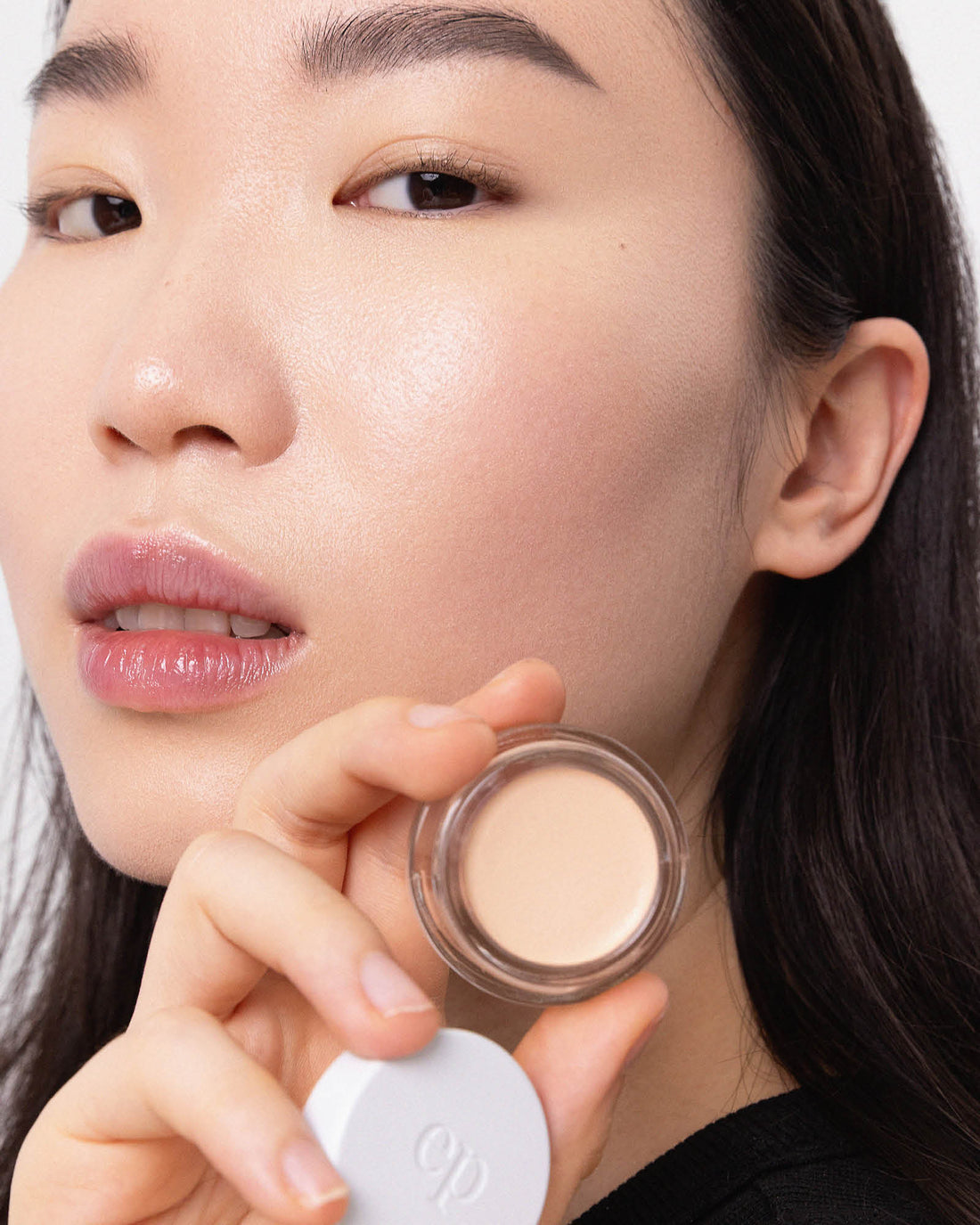 Person has applied Arnica All Cover Pot to their face with a close-up of the product. Arnica All Cover Pot in the shade Latte 