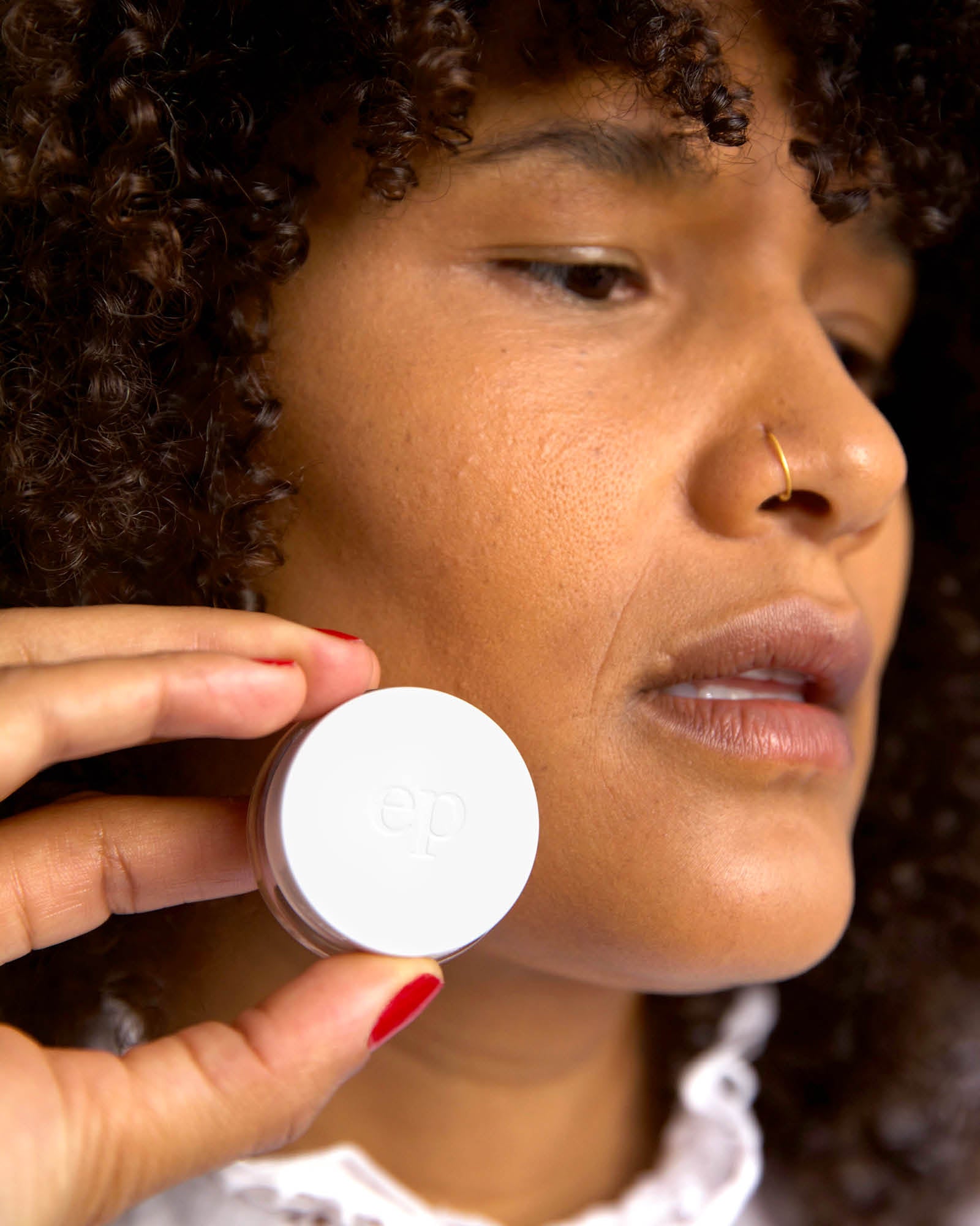 Person has applied Arnica All Cover pot and holding the product 
