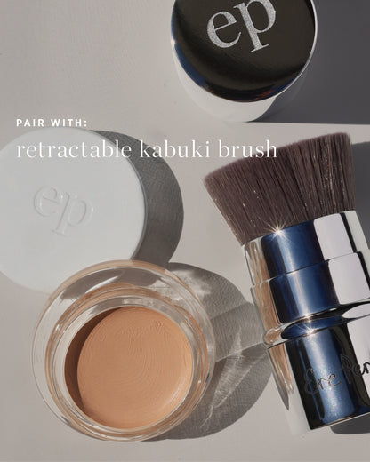 One retractable kabuki brush, next to Arnica All Cover Pot 