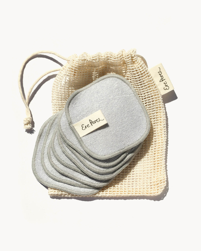 Set of gray reusable pads with a mesh storage bag on a white background