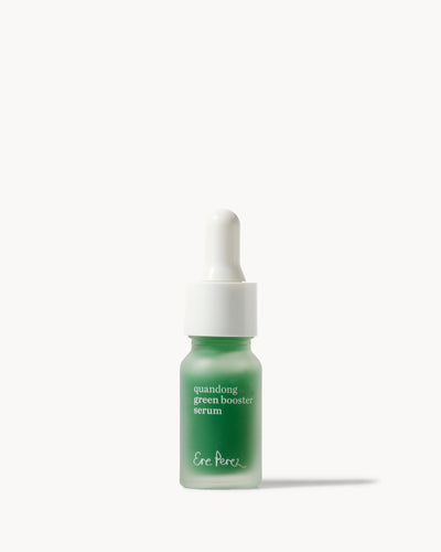 A small dropper bottle of Ere perez Quandong Green Booster Serum with a frosted green glass bottle and a white dropper cap, centered on a clean off-white background 