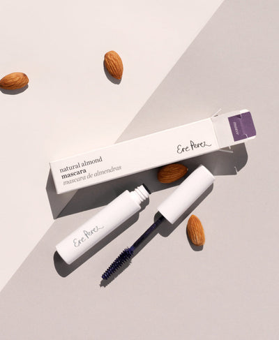 Mauve natural almond mascara by Ere Perez in its tube packaging surrounded by its star ingredient: almonds 