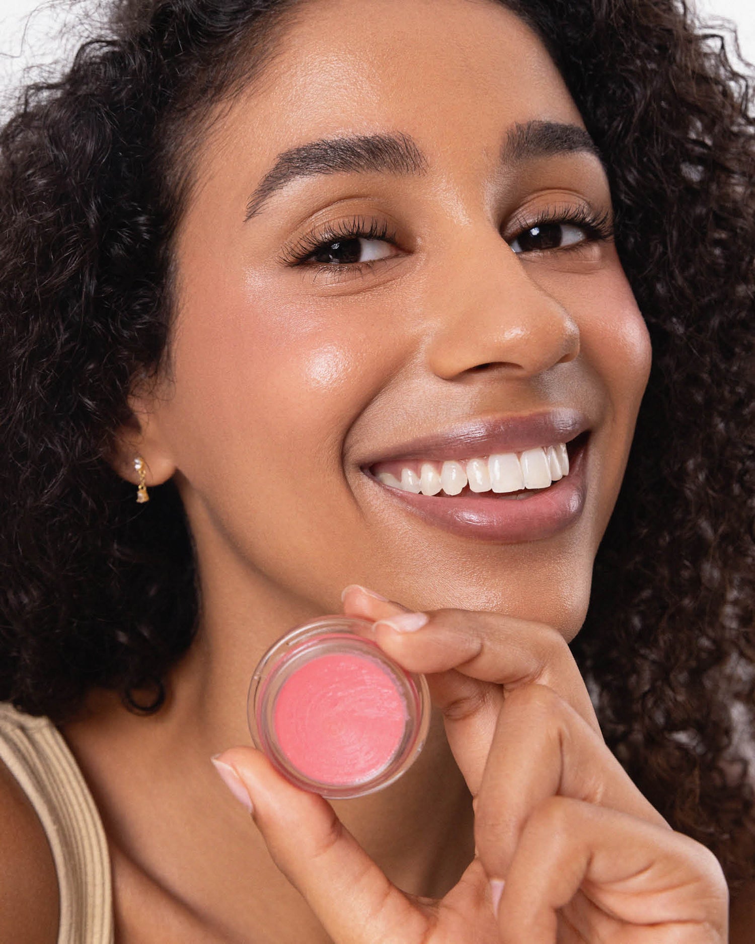 Woman holding a pink blush compact with a neutral background. Carrot Colour Pot in Humble #shade_humble