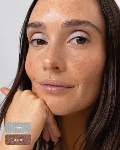Model applying Light Shimmer eyeshadow with a soft makeup brush. #shade_light-shimmer