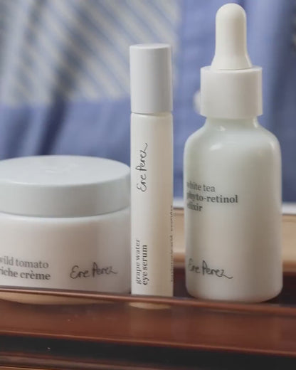 Radiance restore set and swatches by Ere Perez with white tea photo-retinol elixir bottle , grape water eye serum tube and wild tomato riche creme pot for hydrating rejuvenating effect